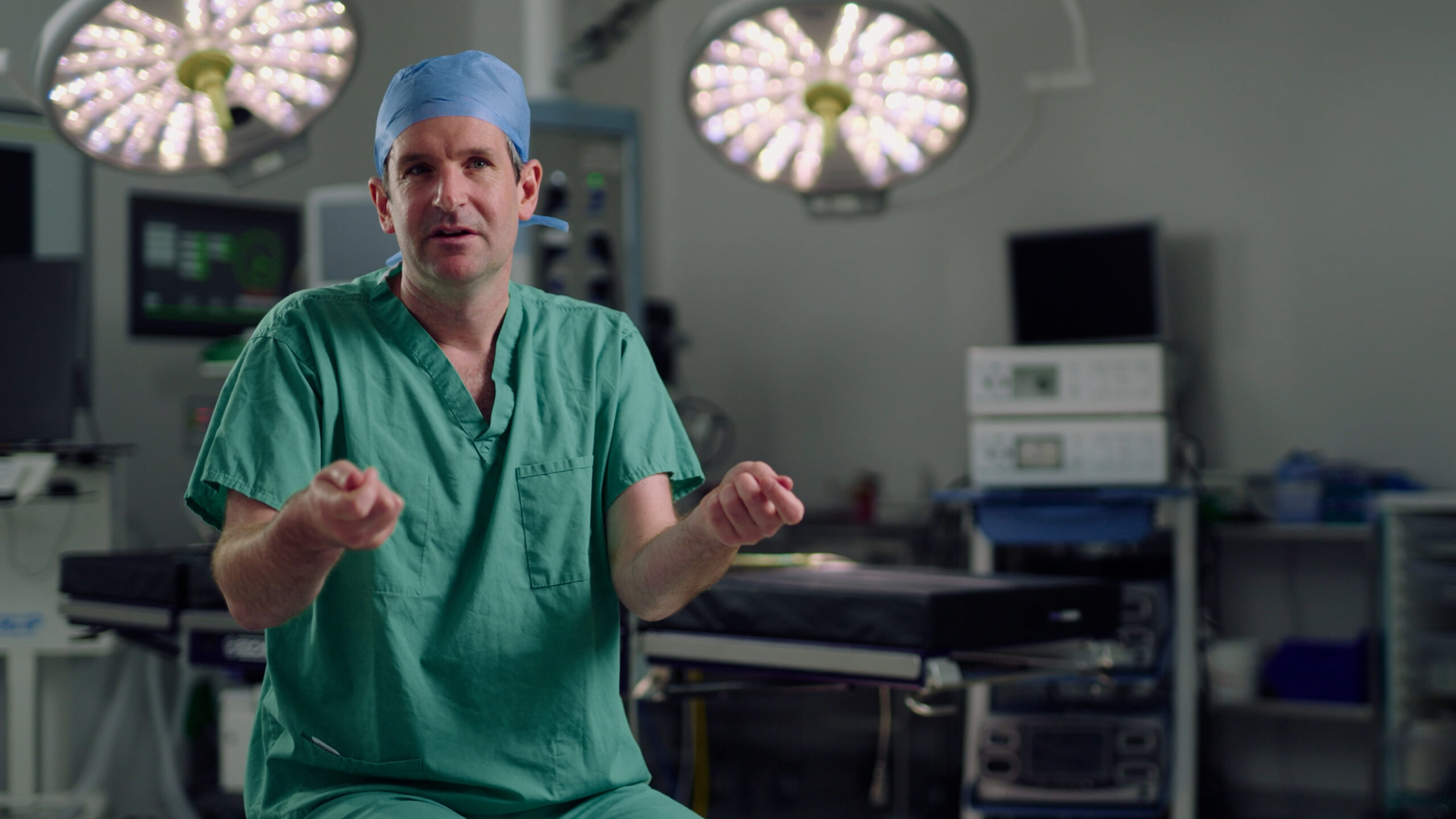 An NHS hospital surgeon being interviewed on camera.